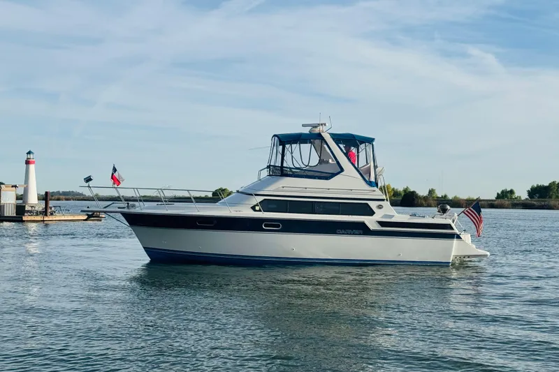 Slide: The Image of 1989 Carver 38 Santego yacht on calm water near a lighthouse. - 8