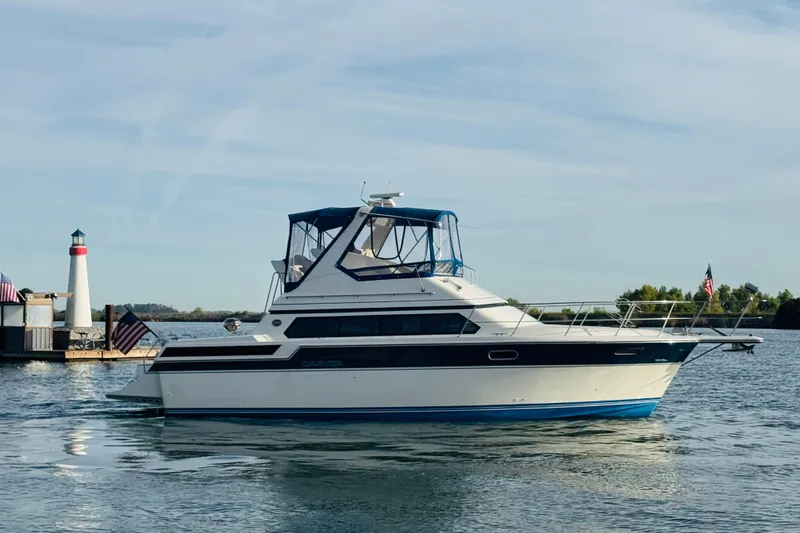 Slide: The Image of 1989 Carver 38 Santego yacht on calm water near a lighthouse. - 80