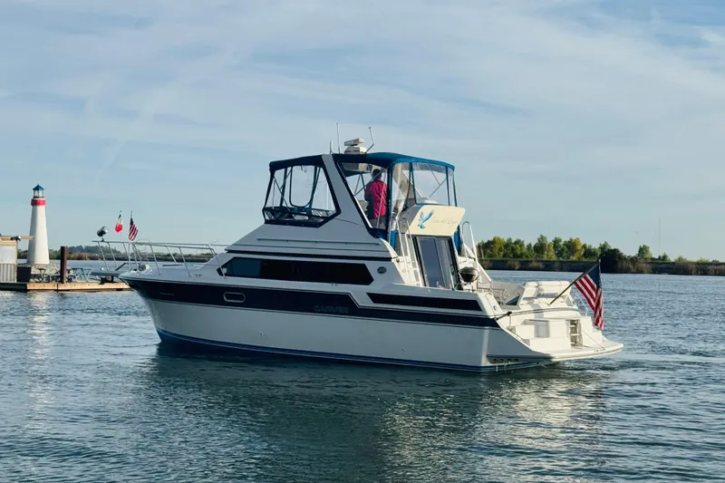 Slide: The Image of 1989 Carver 38 Santego yacht on calm water near a lighthouse. - 9