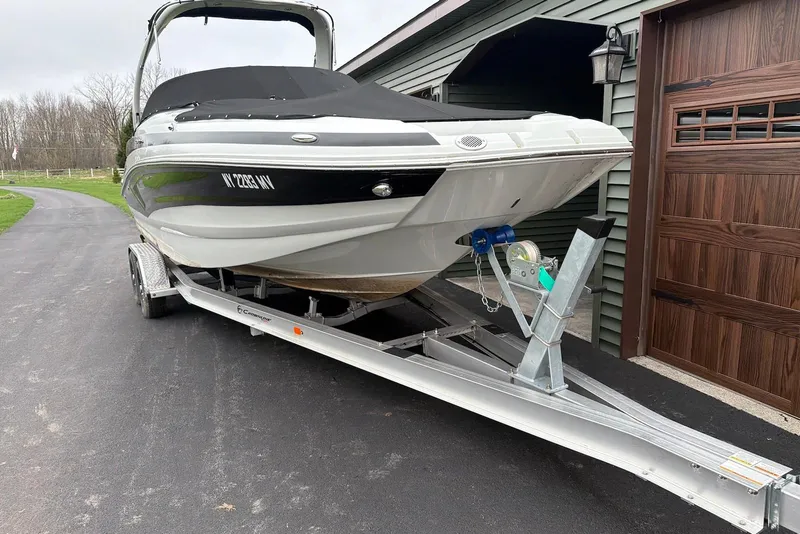 Slide: The Image of 2023 Crownline Eclipse E285 XS boat on trailer beside garage. - 16