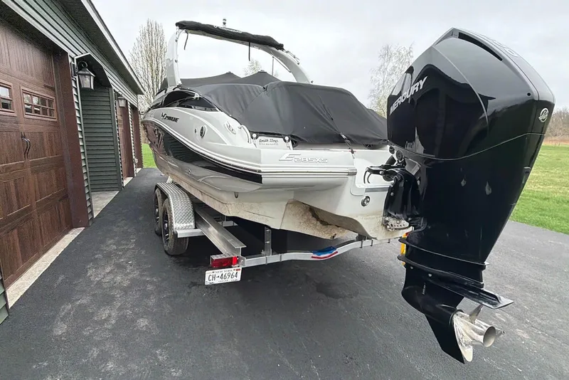 Slide: The Image of 2023 Crownline Eclipse E285 XS boat on trailer, covered, with Mercury outboard motor. - 18