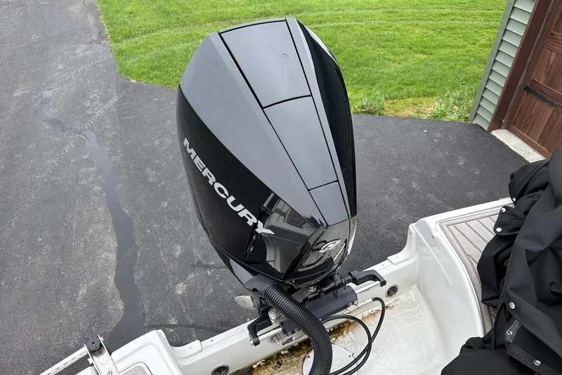 Slide: The Image of 2023 Crownline Eclipse E285 XS with Mercury outboard motor on driveway. - 19