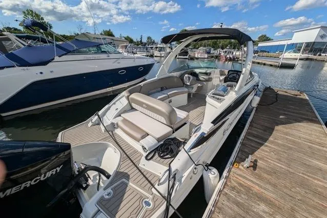 Slide: The Image of 2023 Crownline Eclipse E285 XS boat docked, featuring spacious seating and sleek design. - 4