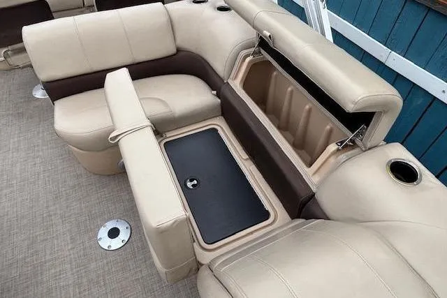 Slide: The Image of 2019 Sun Tracker SportFish 22 DLX boat interior with beige seating and storage compartments. - 18