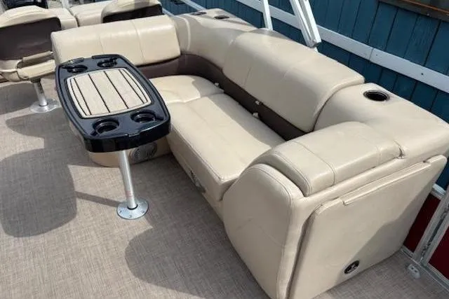 Slide: The Image of 2019 Sun Tracker SportFish 22 DLX pontoon boat interior with beige seating and a table. - 19