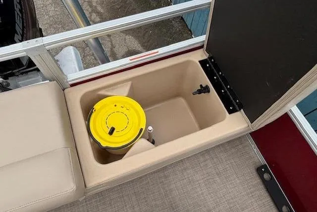 Slide: The Image of 2019 Sun Tracker SportFish 22 DLX boat storage compartment with yellow bucket and beige seating. - 29