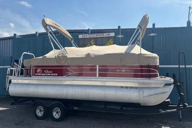 Slide: The Image of 2019 Sun Tracker SportFish 22 DLX pontoon boat with canopy, parked on a trailer. - 32