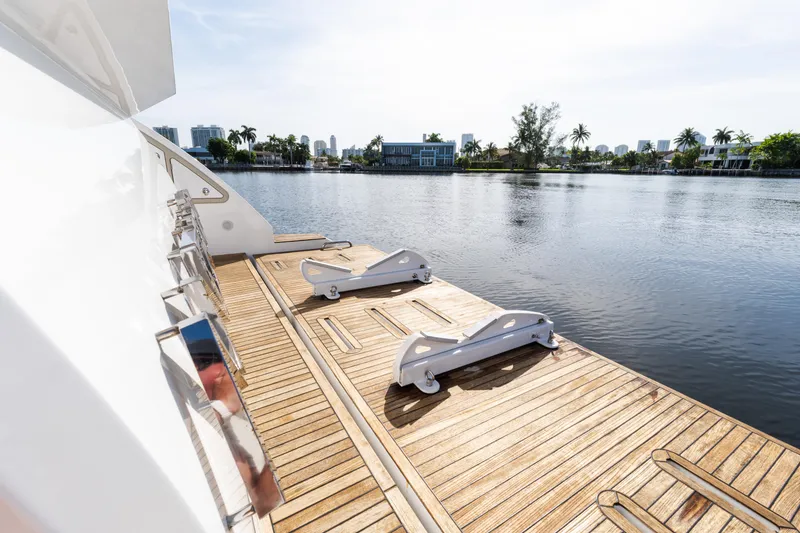 Slide: The Image of 2023 Azimut Fly 50 yacht deck with waterfront view, featuring sleek wooden design. - 23