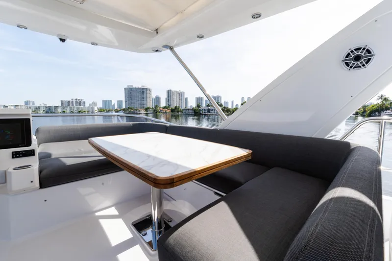Slide: The Image of 2023 Azimut Fly 50 yacht interior with elegant seating and table, overlooking city skyline. - 48