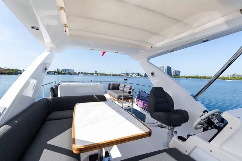Slide: The Image of 2023 Azimut Fly 50 yacht interior with luxurious seating and scenic waterfront view. - 52