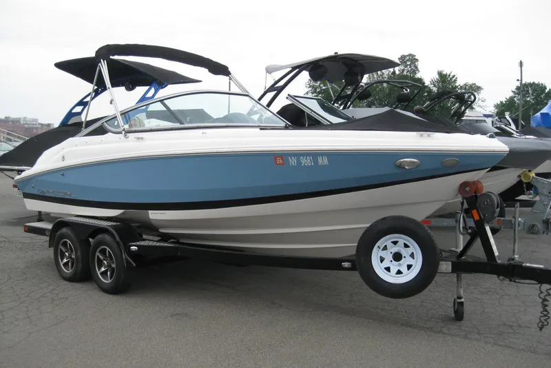 Slide: The Image of 2017 Regal 2000 ES Bowrider on trailer, blue and white, parked outdoors. - 2