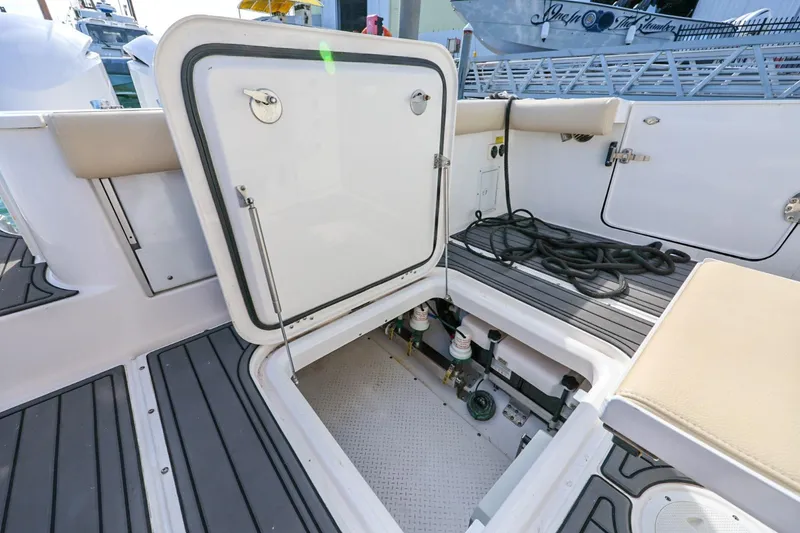 Slide: The Image of Open hatch on 2017 Everglades 355 Center Console boat, revealing storage and equipment. - 101