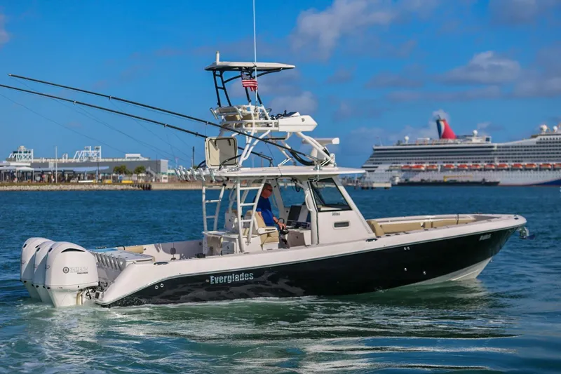 Slide: The Image of 2017 Everglades 355 Center Console boat cruising near a cruise ship in a harbor. - 12