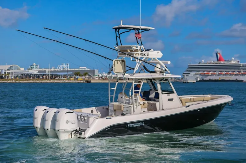 Slide: The Image of 2017 Everglades 355 Center Console boat cruising in a harbor with a cruise ship in the background. - 13