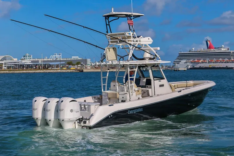 Slide: The Image of 2017 Everglades 355 Center Console boat cruising near a port with a cruise ship. - 14