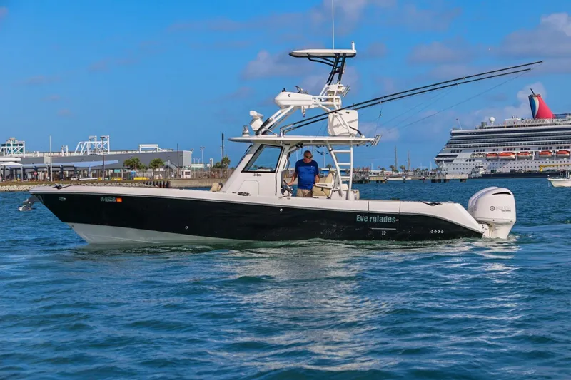 Slide: The Image of 2017 Everglades 355 Center Console boat cruising in a harbor with a cruise ship in the background. - 19