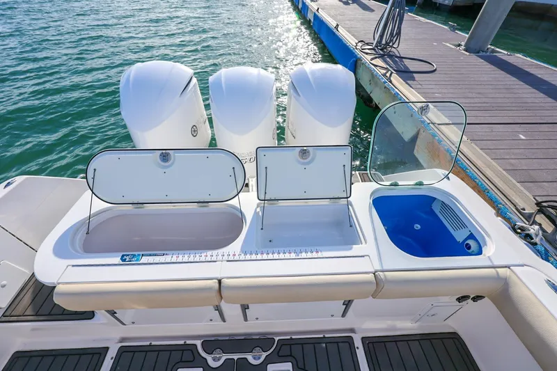 Slide: The Image of 2017 Everglades 355 Center Console boat with open storage compartments and triple engines. - 25