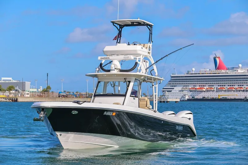 Slide: The Image of 2017 Everglades 355 Center Console boat cruising near a large cruise ship in a harbor. - 3