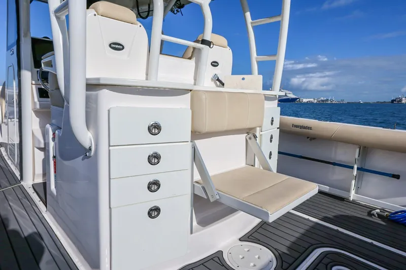 Slide: The Image of 2017 Everglades 355 Center Console boat interior with seating and storage, docked by the ocean. - 31