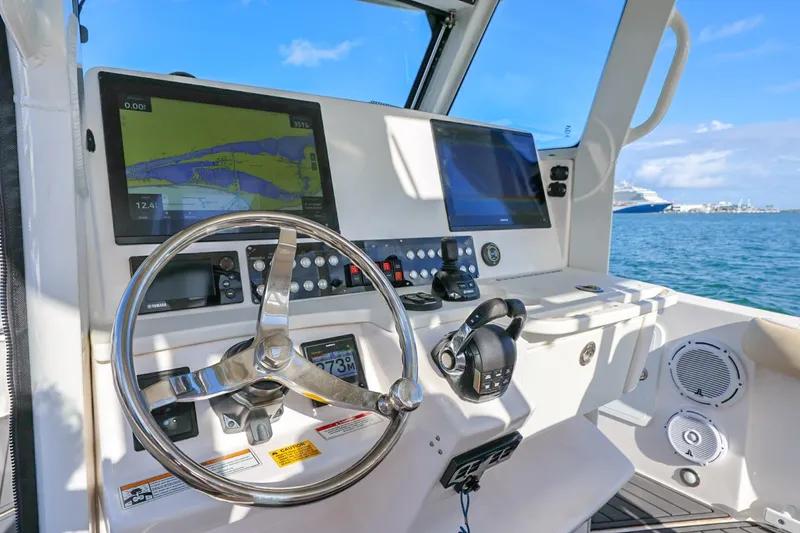 Slide: The Image of 2017 Everglades 355 Center Console helm with navigation screens and steering wheel. - 34