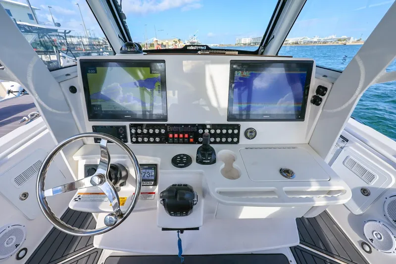 Slide: The Image of 2017 Everglades 355 Center Console boat dashboard with dual navigation screens and steering wheel. - 35