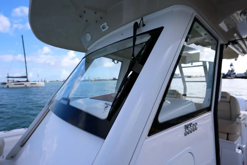 Slide: The Image of 2017 Everglades 355 Center Console boat on water, showcasing sleek design and windshield. - 48