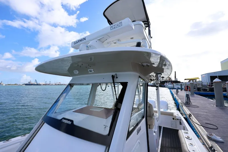 Slide: The Image of 2017 Everglades 355 Center Console boat docked, featuring Garmin equipment, under a clear sky. - 49