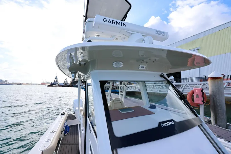 Slide: The Image of 2017 Everglades 355 Center Console boat docked, featuring Garmin equipment and sleek design. - 52