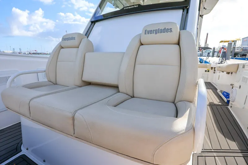 Slide: The Image of 2017 Everglades 355 Center Console boat with beige seating, docked under a blue sky. - 61