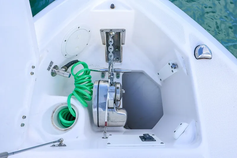 Slide: The Image of Anchor locker of a 2017 Everglades 355 Center Console boat with green hose and chain. - 64