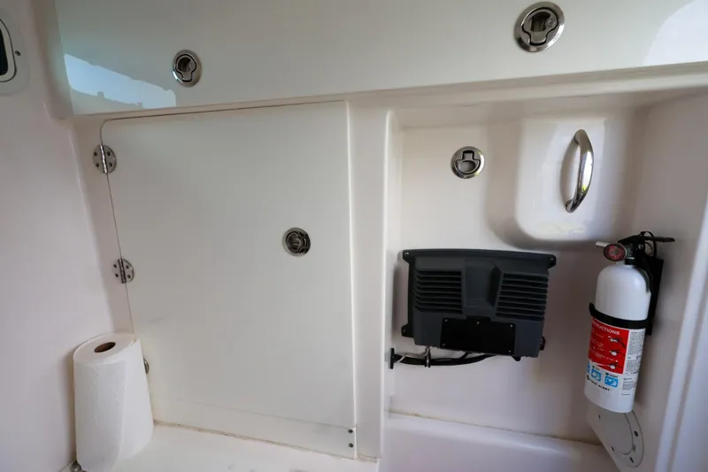 Slide: The Image of Interior of 2017 Everglades 355 Center Console with storage, fire extinguisher, and paper towel. - 66