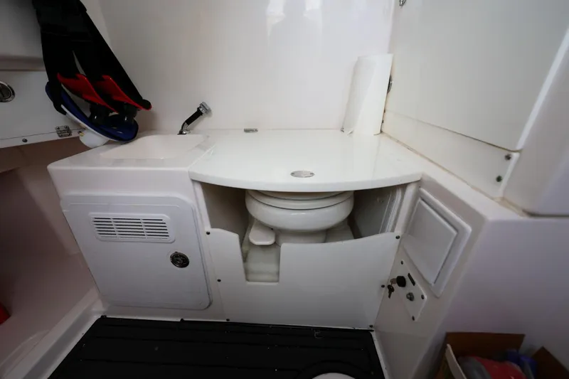 Slide: The Image of 2017 Everglades 355 Center Console boat bathroom with compact toilet and storage. - 68