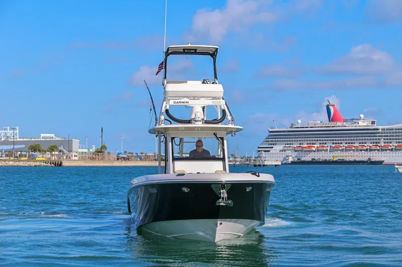 Slide: The Image of 2017 Everglades 355 Center Console boat cruising near a large cruise ship in a harbor. - 7