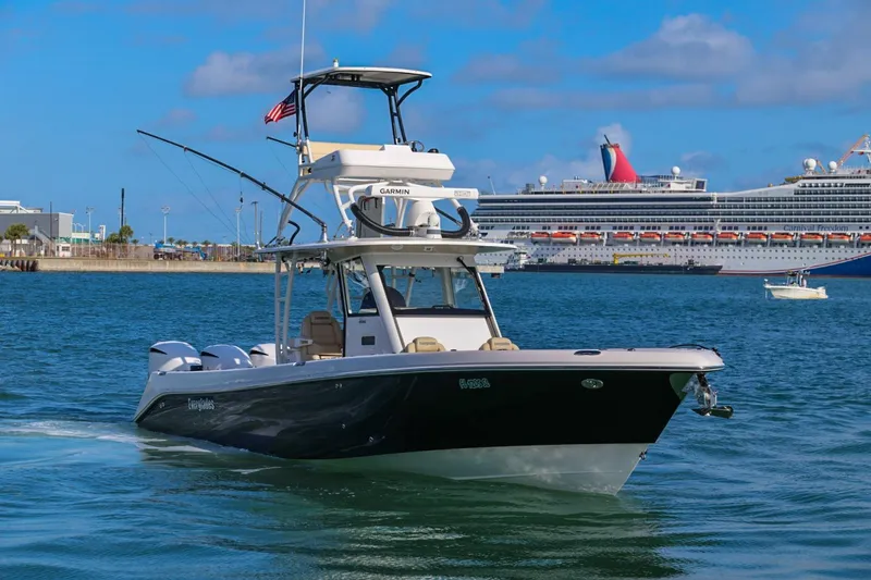 Slide: The Image of 2017 Everglades 355 Center Console boat cruising near a large cruise ship in a harbor. - 8