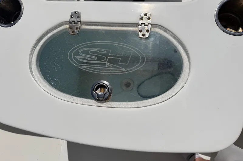 Slide: The Image of Close-up of a 2017 Sea Hunt Triton 210 boat compartment with SH logo. - 17