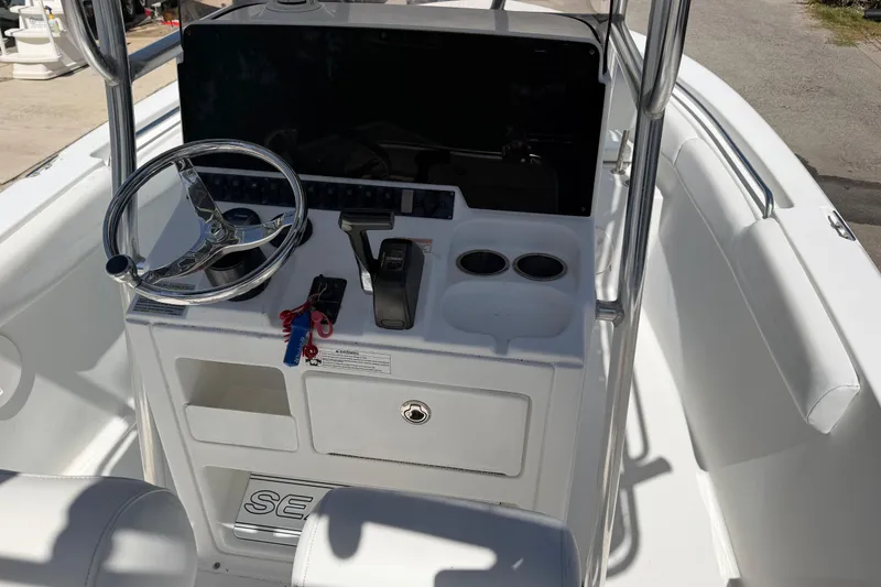 Slide: The Image of 2017 Sea Hunt Triton 210 boat console with steering wheel and controls. - 19