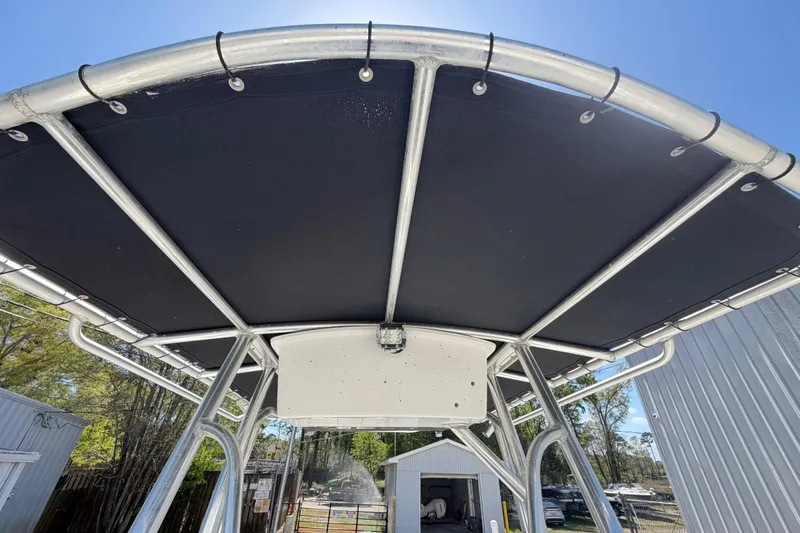 Slide: The Image of 2017 Sea Hunt Triton 210 T-top canopy with metal frame under clear blue sky. - 25