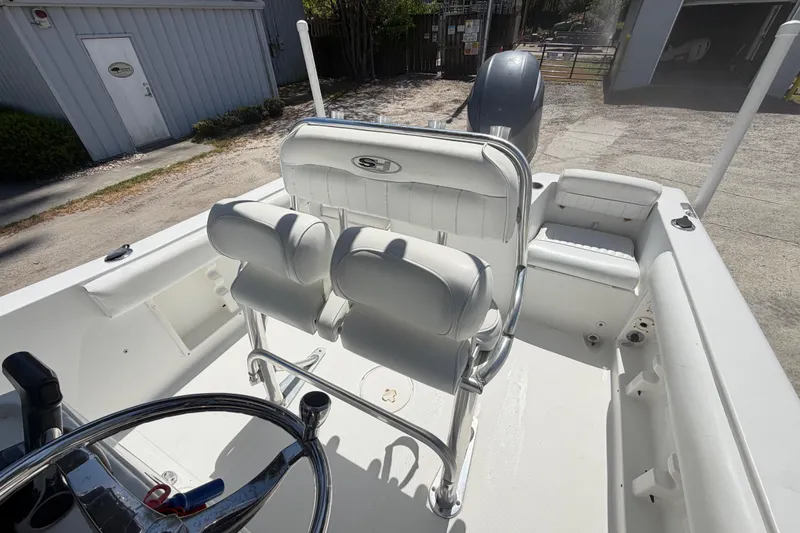 Slide: The Image of 2017 Sea Hunt Triton 210 boat interior with white seating and steering wheel. - 30