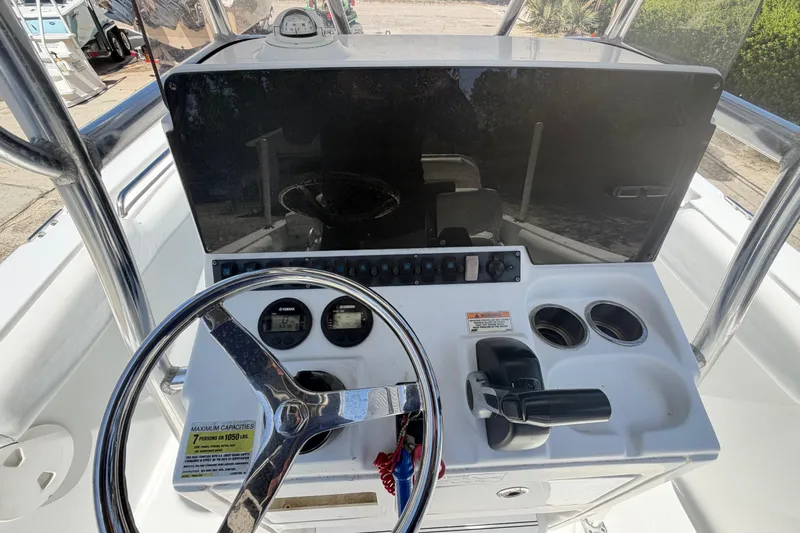 Slide: The Image of 2017 Sea Hunt Triton 210 boat dashboard with steering wheel and controls. - 31