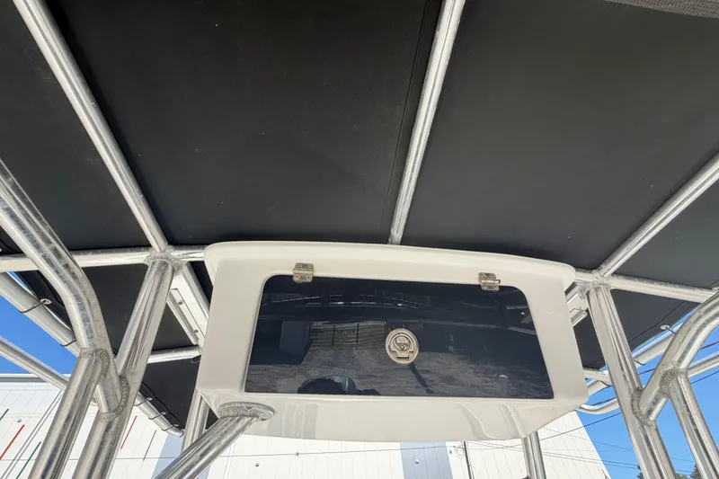 Slide: The Image of 2017 Sea Hunt Triton 210 T-top with storage compartment, showcasing sturdy metal framework. - 34