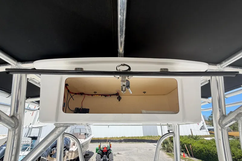 Slide: The Image of 2017 Sea Hunt Triton 210 boat console storage with wiring and open compartment. - 35