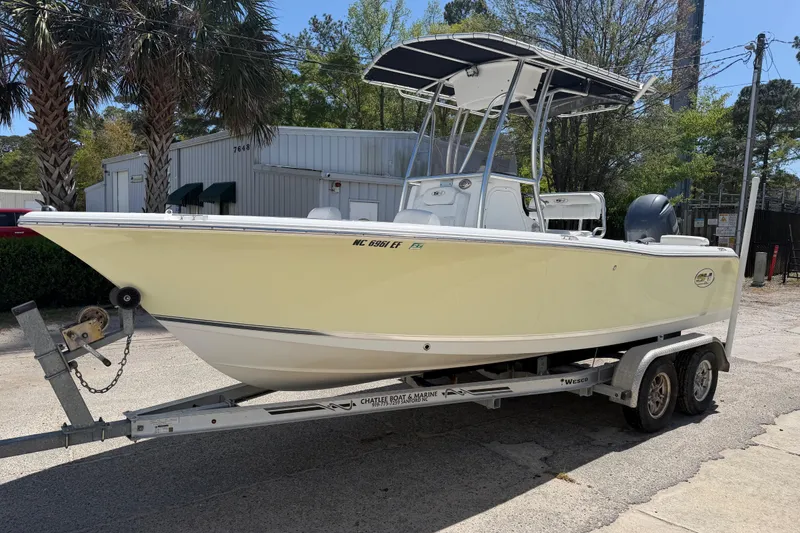 Slide: The Image of 2017 Sea Hunt Triton 210 boat on trailer, parked outdoors near palm trees. - 4