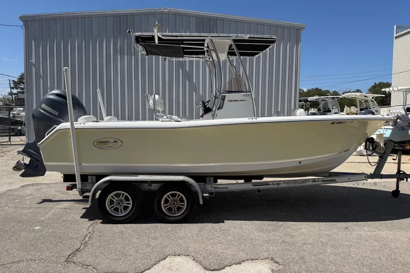 Slide: The Image of 2017 Sea Hunt Triton 210 boat on trailer, parked outdoors near metal building. - 8