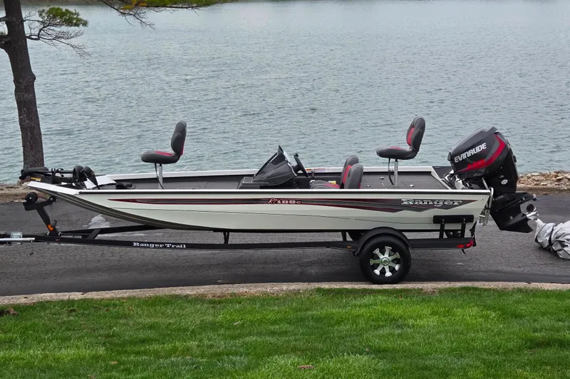 The Image of 2018 Ranger RT188C fishing boat on trailer by a lake. - 0