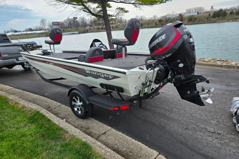 Slide: The Image of 2018 Ranger RT188C boat with Evinrude motor on trailer by a lake. - 1