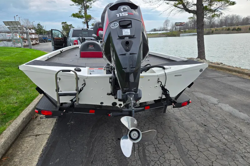 Slide: The Image of 2018 Ranger RT188C boat with outboard motor, parked near a lake. - 2