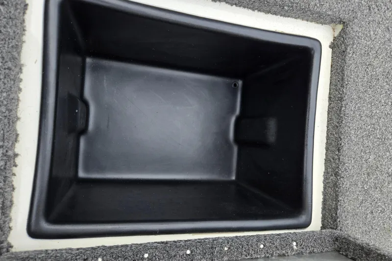 Slide: The Image of 2018 Ranger RT188C boat storage compartment with black interior and gray carpeted edges. - 24