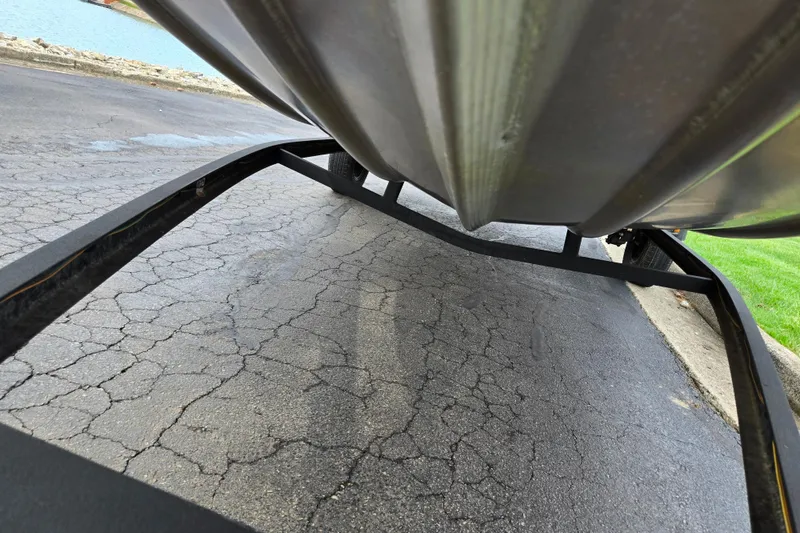 Slide: The Image of Underside view of a 2018 Ranger RT188C boat on a trailer, parked on cracked pavement. - 7