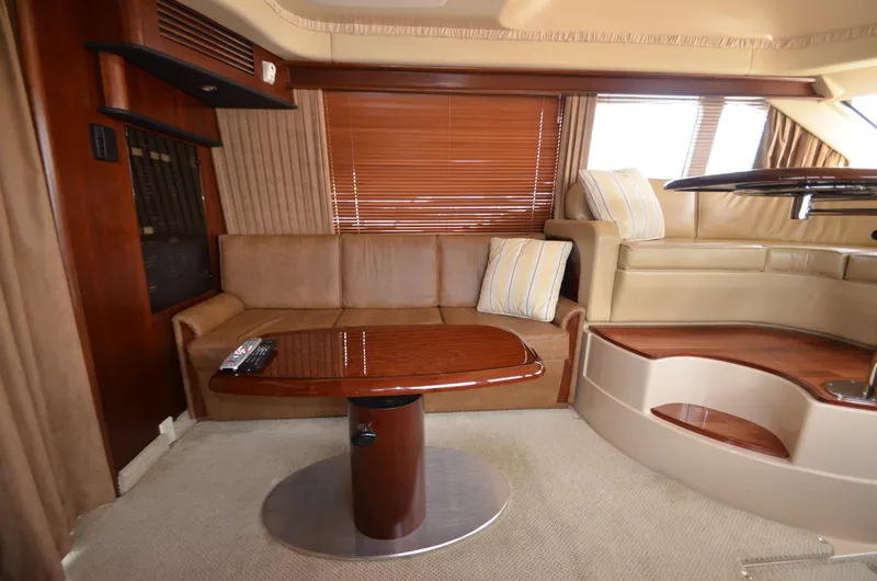 Slide: The Image of Interior of 2005 Sea Ray 420 Sedan Bridge with leather sofa and wooden table. - 10