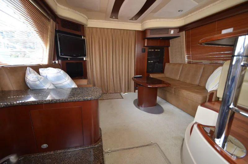 Slide: The Image of Interior of 2005 Sea Ray 420 Sedan Bridge, luxurious living area with sofa and TV. - 12